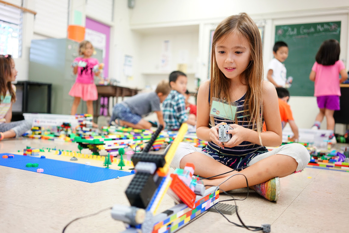 A child operating a Lego robot