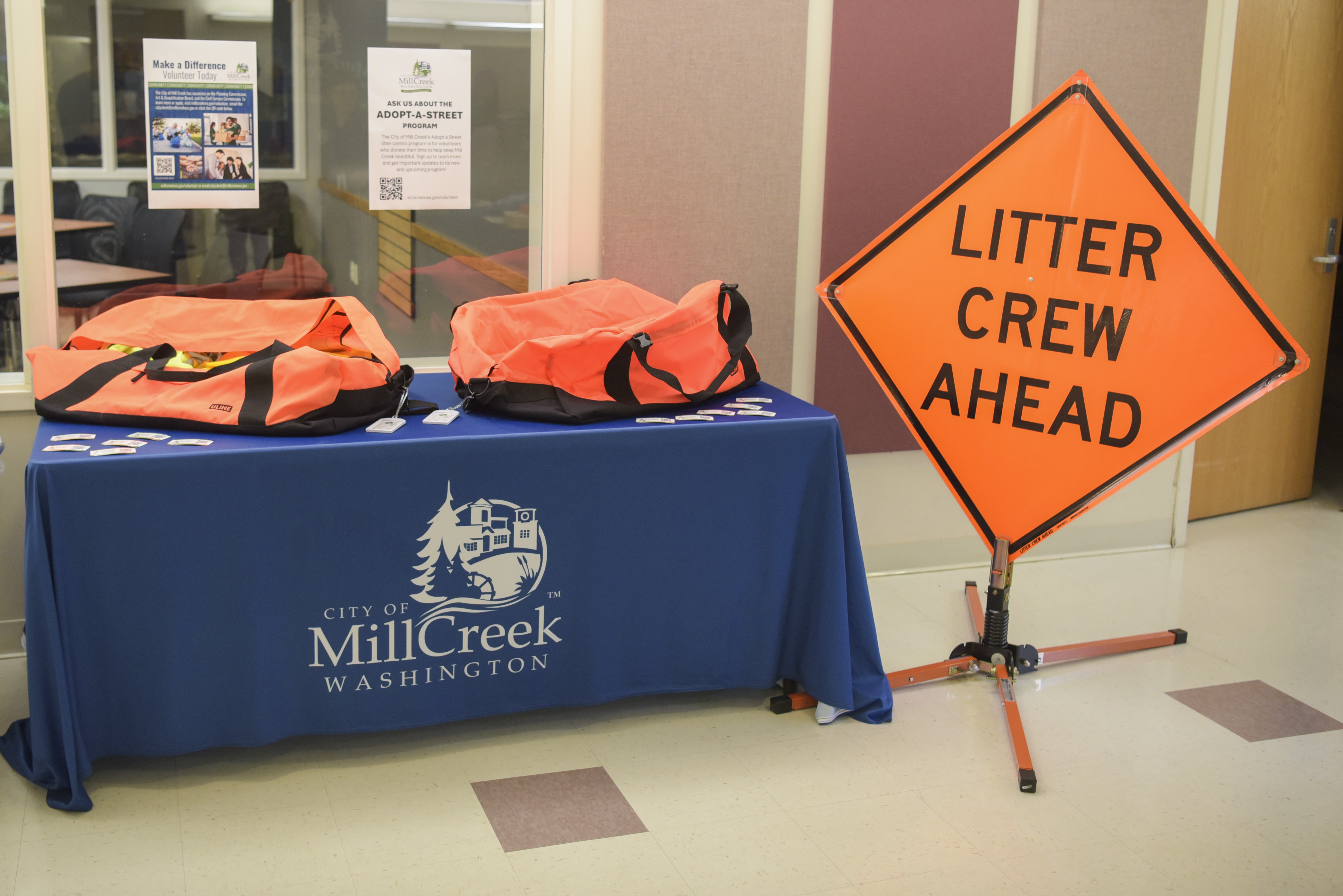 City of Mill Creek table holding litter crew cleanup bags with a Litter Crew Ahead sign next to it.